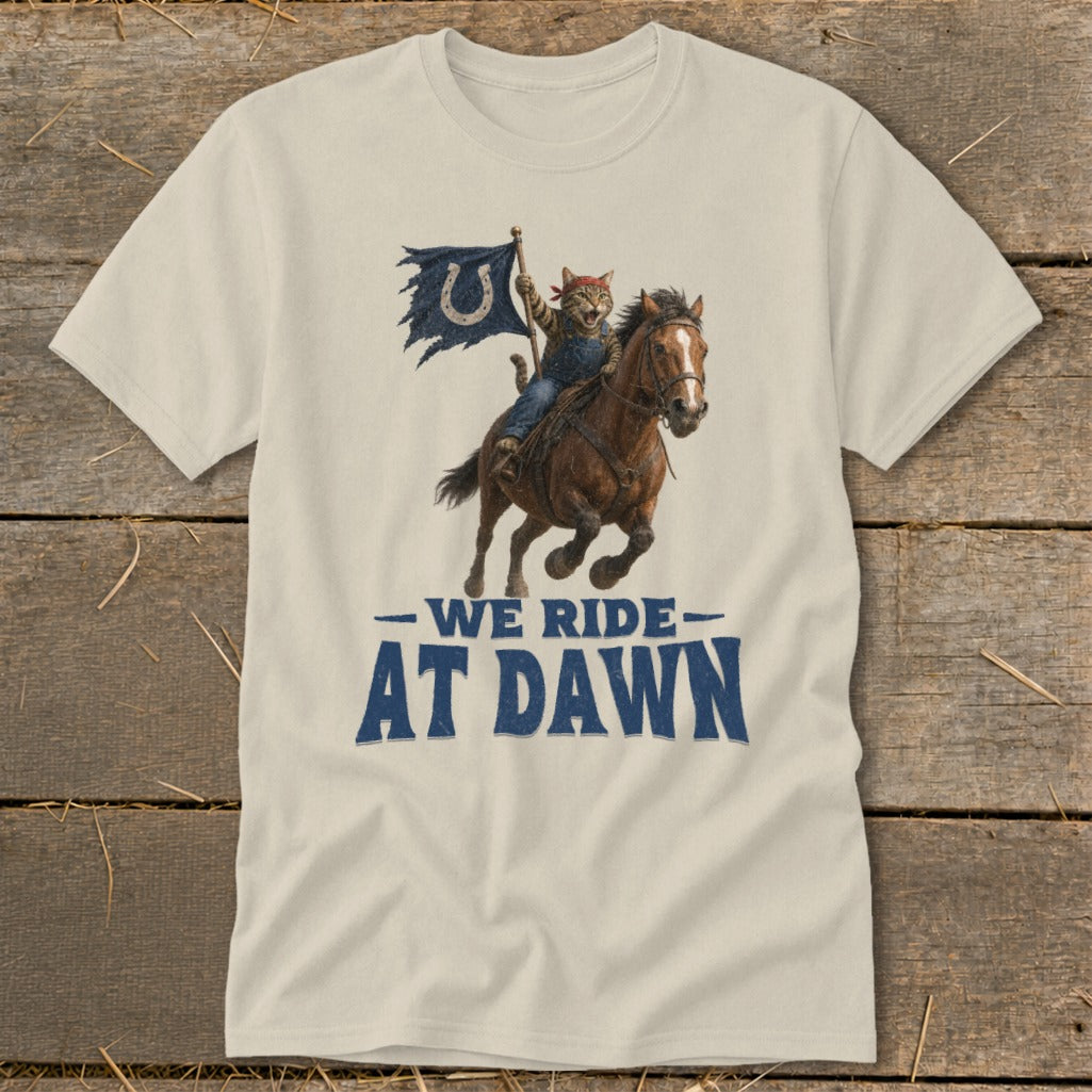 Cat wearing bandana rides horse, holds torn flag with horseshoe logo. Text reads: We Ride at Dawn.