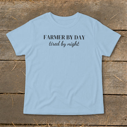Light blue t-shirt with black text reading "FARMER BY DAY tired by night".
