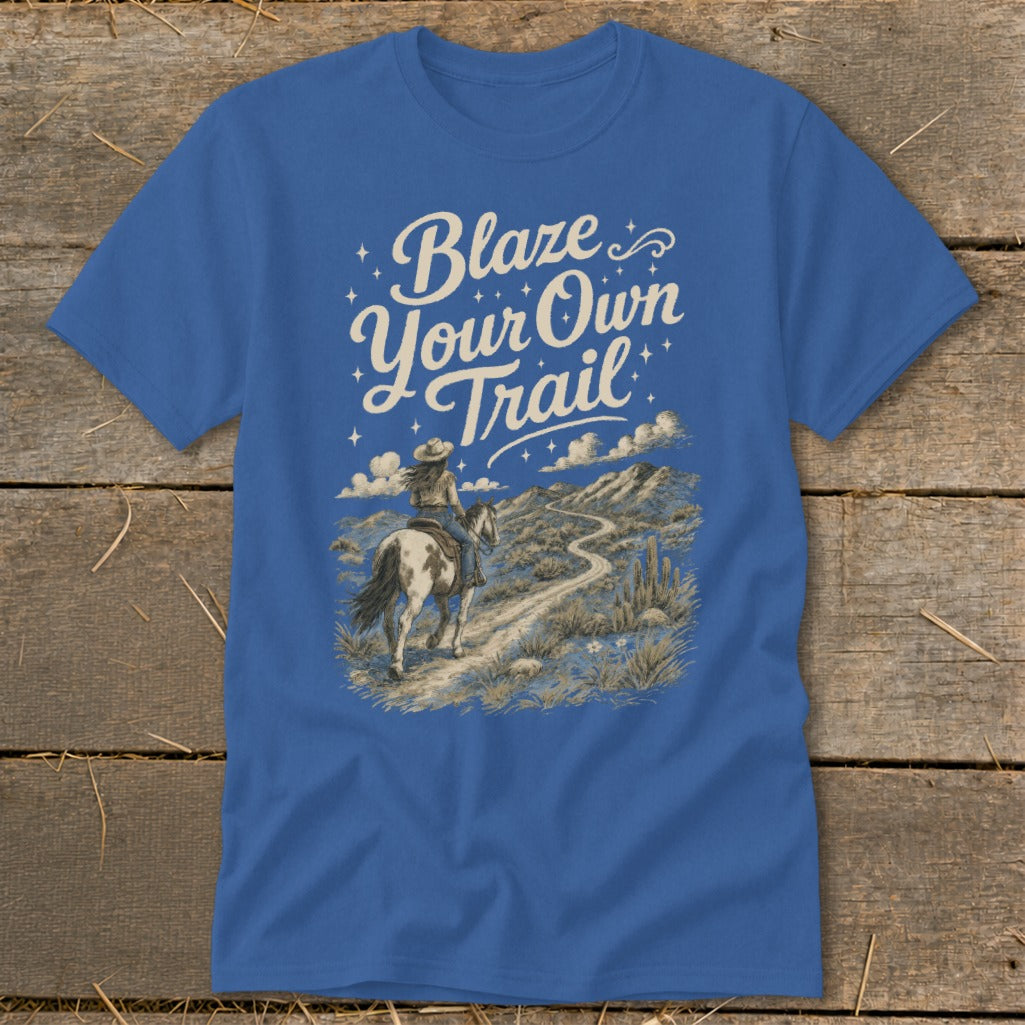 T-shirt with text "Blaze Your Own Trail" and illustration of woman riding horse on desert path.