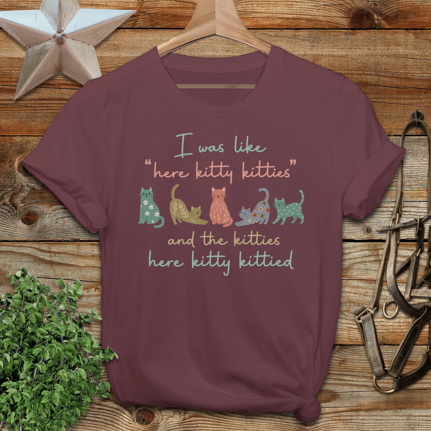 Maroon t-shirt with colorful cats and "here kitty kitties" text.
