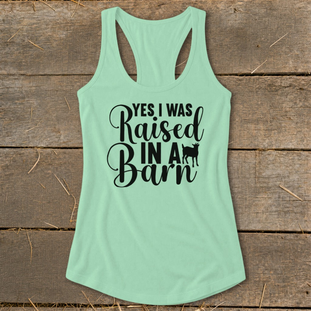 Light green tank top with black text and goat graphic saying "Yes I Was Raised In A Barn".