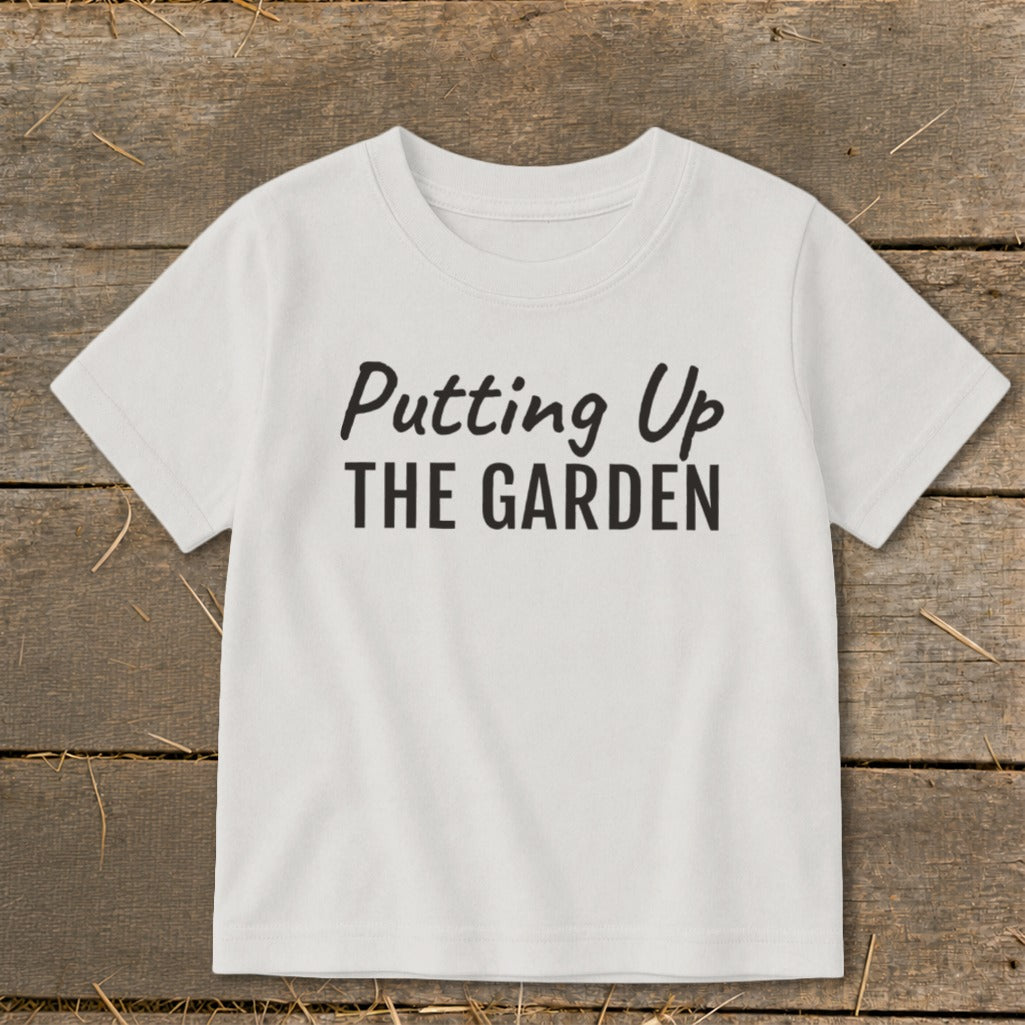 White t-shirt with "Putting Up THE GARDEN" text in black.