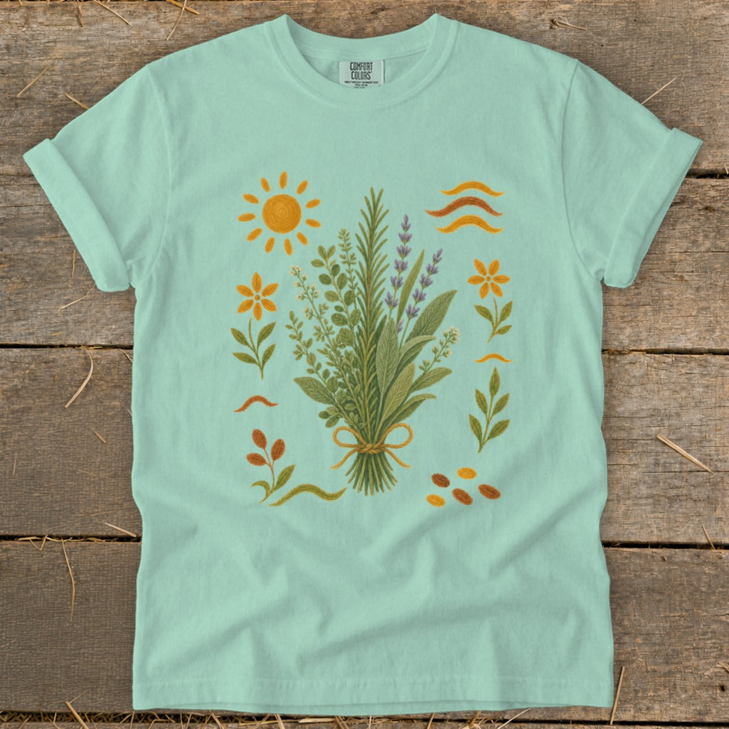 Mint t-shirt with a bouquet of herbs, sun, and flowers graphic.