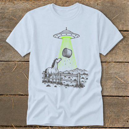 UFO beams hay bale down onto a horse behind a fence with mountains in background.