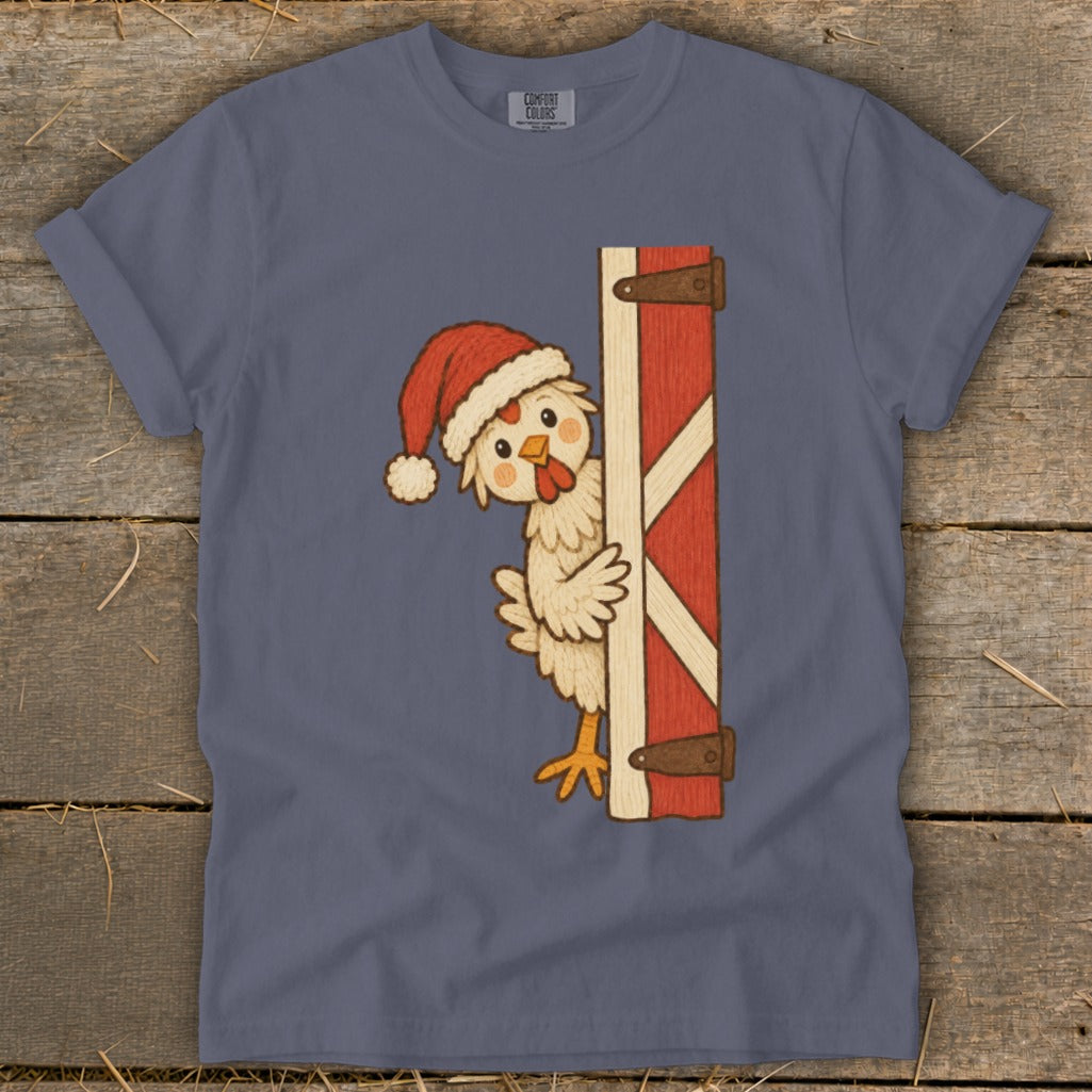 Chicken wearing a Santa hat peeks around a red barn door.