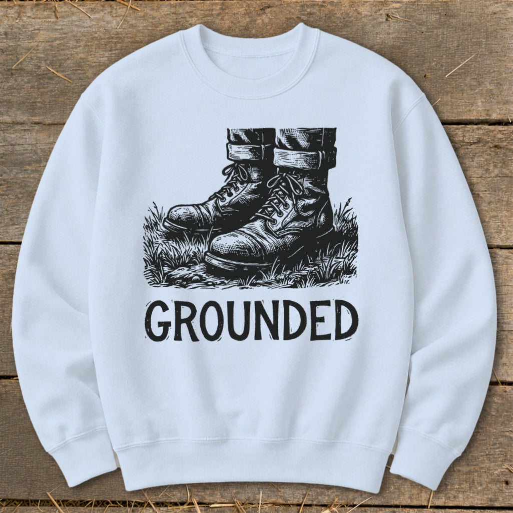 Light blue crewneck sweatshirt with black graphic of boots in grass and the word GROUNDED.