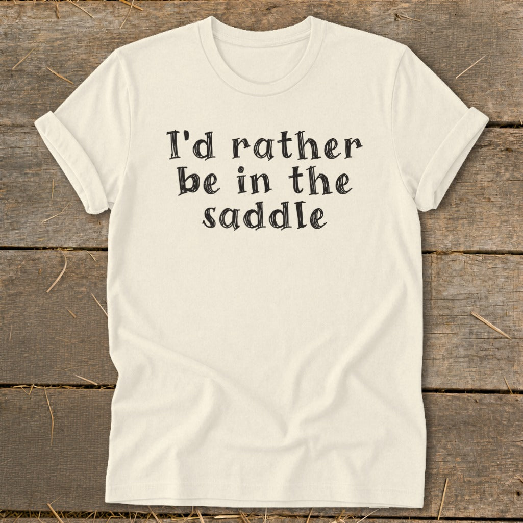 Cream t-shirt with "I'd rather be in the saddle" printed in black text.