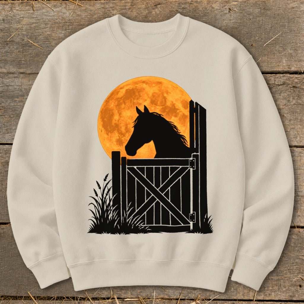 A cream-colored crewneck sweatshirt featuring a graphic of a horse silhouetted against a large orange moon.