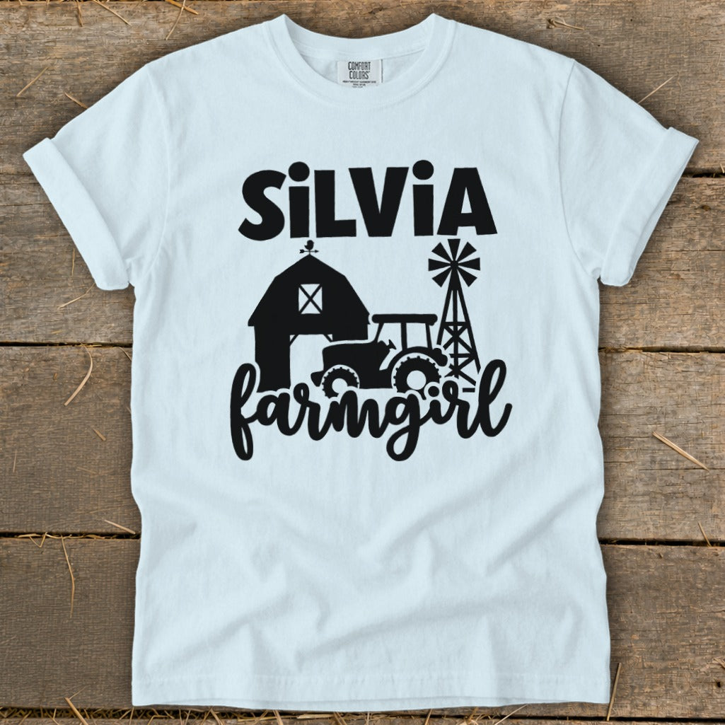 White t-shirt with "Silvia farmgirl" and farm graphic in black.