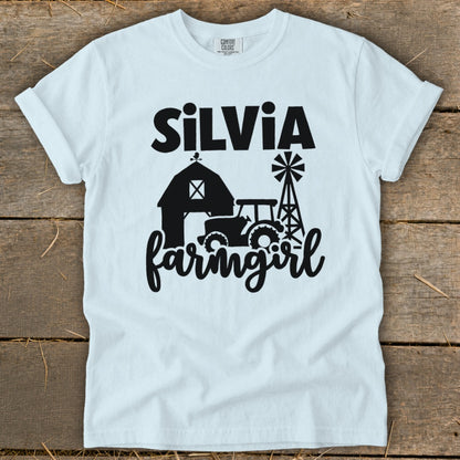 White t-shirt with "Silvia farmgirl" and farm graphic in black.