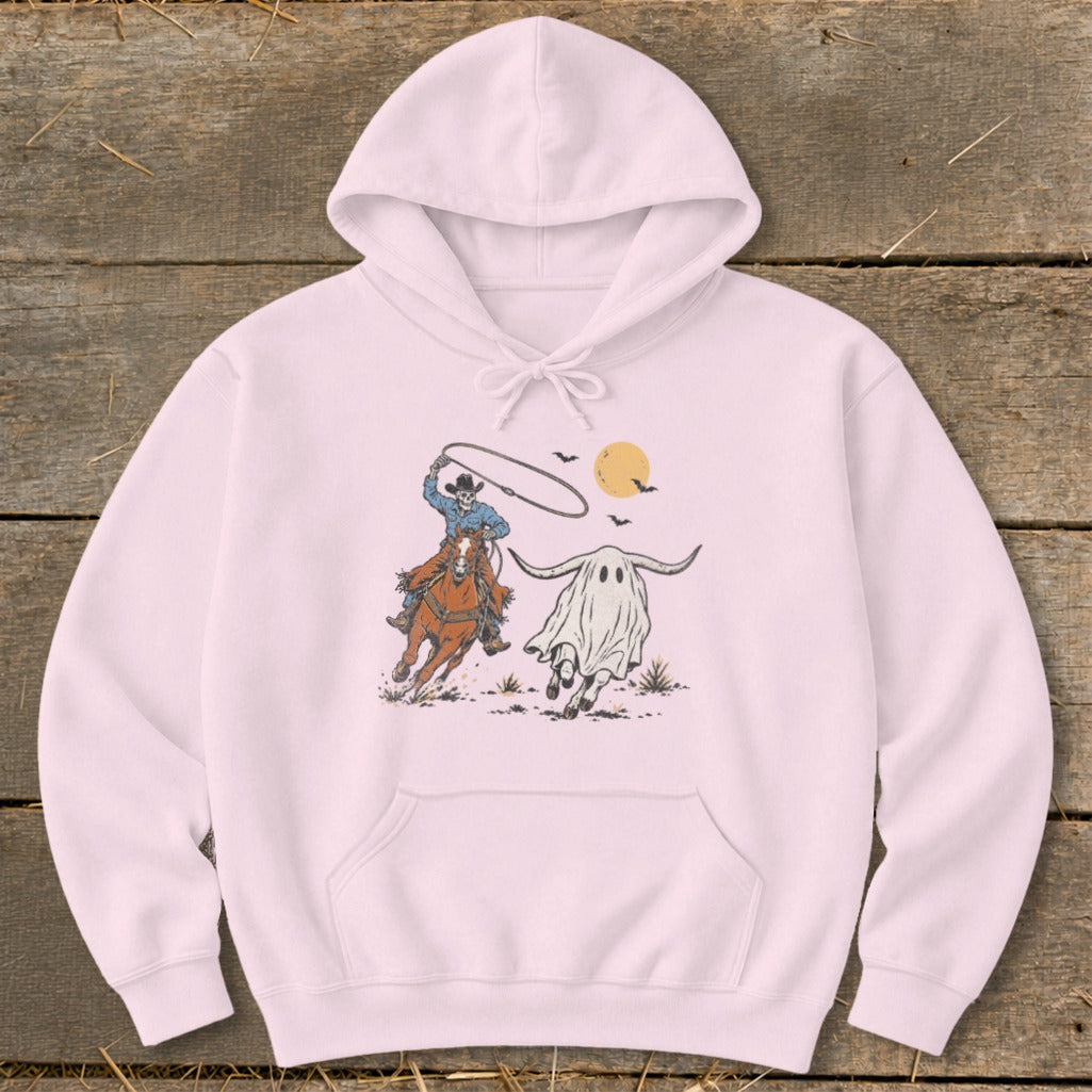 Skeleton cowboy on horseback lassoing a running ghost with bull horns under a full moon.