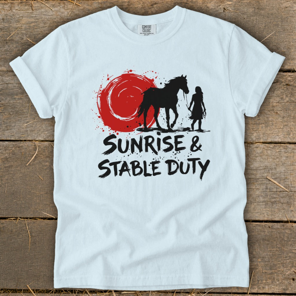 White t-shirt with black silhouette of horse, rider, and red sun graphic, text "SUNRISE & STABLE DUTY".