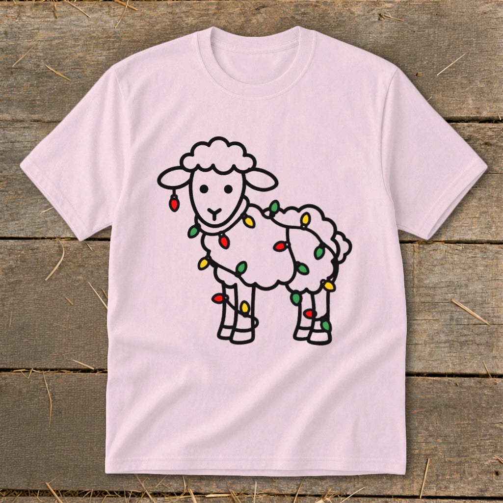 A light pink t-shirt displays a black-outline graphic of a sheep wrapped in colorful holiday lights.