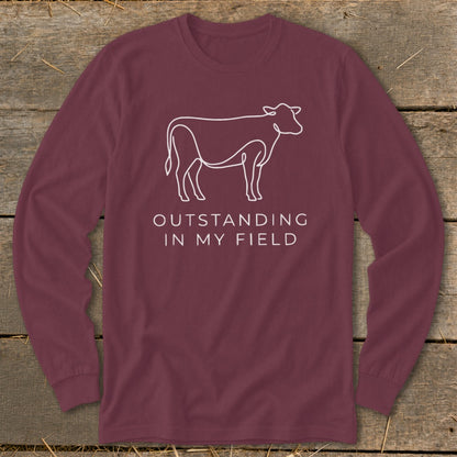 Maroon long-sleeve shirt with white line drawing of a cow and text "OUTSTANDING IN MY FIELD".