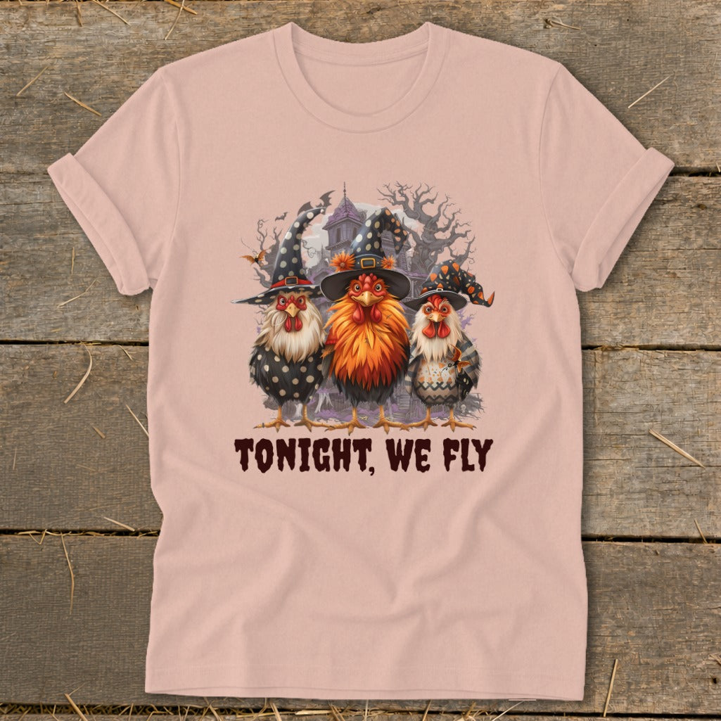 Three chickens in witch hats stand in front of a spooky house, with text "TONIGHT, WE FLY".