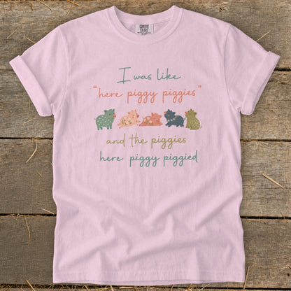 Pink t-shirt with "I was like 'here piggy piggies' and the piggies here piggy piggied" text and cartoon pigs.