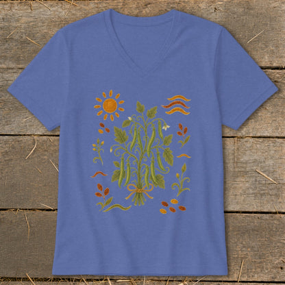 Blue v-neck t-shirt with a colorful illustration of a bean plant, sun, and seeds.