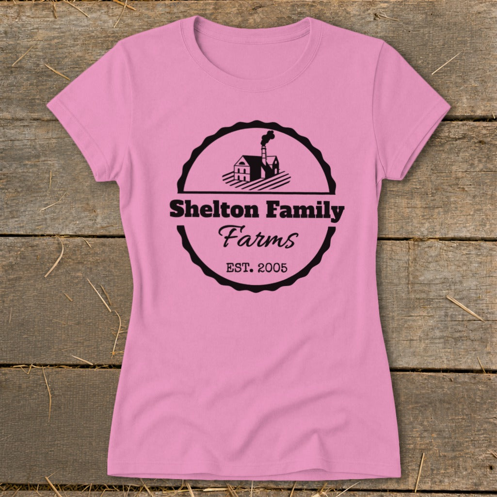 Pink t-shirt with a black circular logo featuring "Shelton Family Farms EST. 2005".