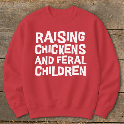 Red sweatshirt with white text: Raising Chickens and Feral Children.