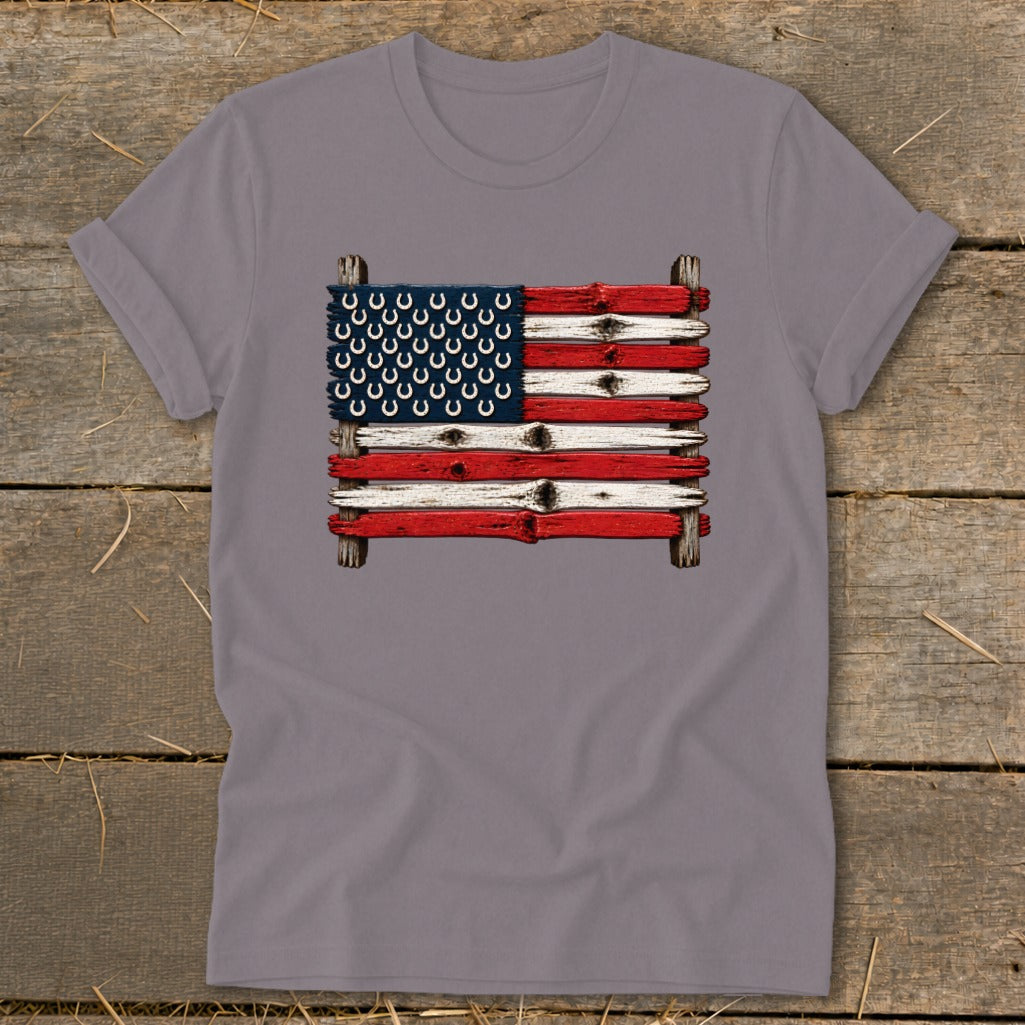 A grey t-shirt featuring a graphic of an American flag made from weathered wooden planks and horseshoes.