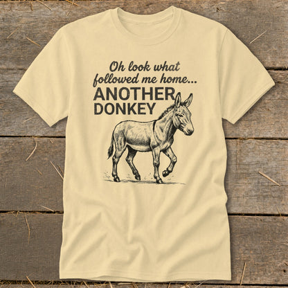 Light yellow t-shirt with black text and donkey graphic saying "Oh look what followed me home... ANOTHER DONKEY".