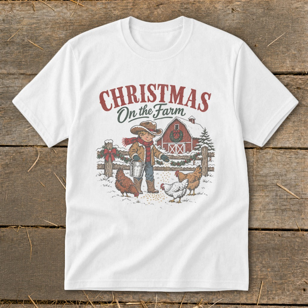 White t-shirt with "Christmas on the Farm" text and illustration of a boy feeding chickens.
