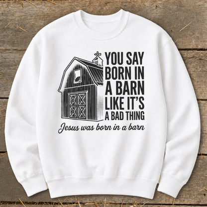 White sweatshirt with a barn graphic and text that reads "You say born in a barn like it's a bad thing. Jesus was born in a barn."