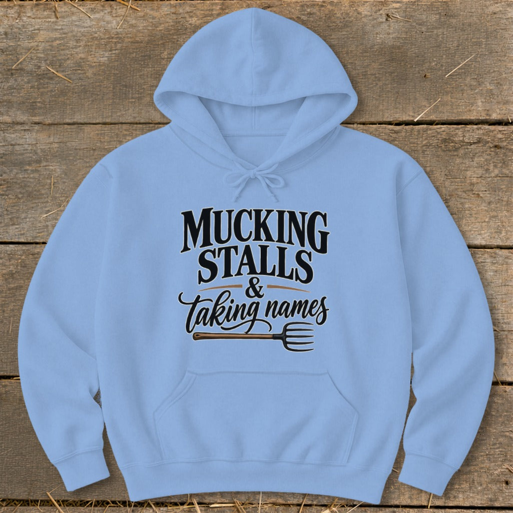 Light blue hoodie with text "MUCKING STALLS & taking names" and a pitchfork.