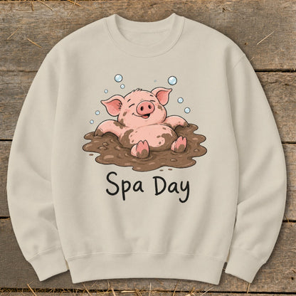 Cream sweatshirt with cartoon pig in mud and "Spa Day" text.