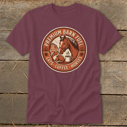 Burgundy t-shirt with circular graphic featuring a horse, cat, and coffee cup. Text reads "Premium Barn Fuel Cats Coffee Horses."
