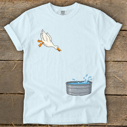 Light blue t-shirt with a cartoon duck jumping into a galvanized water tub.
