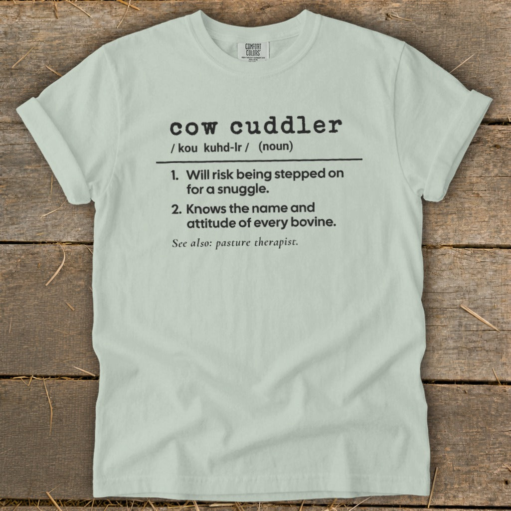 Light blue t-shirt with "cow cuddler" definition printed in black text.
