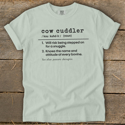 Light blue t-shirt with "cow cuddler" definition printed in black text.