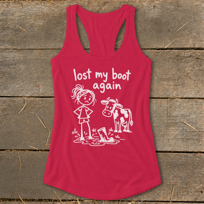 Red women's racerback tank top featuring a graphic of a frustrated stick figure standing by a muddy cow, with white text reading lost my boot again.