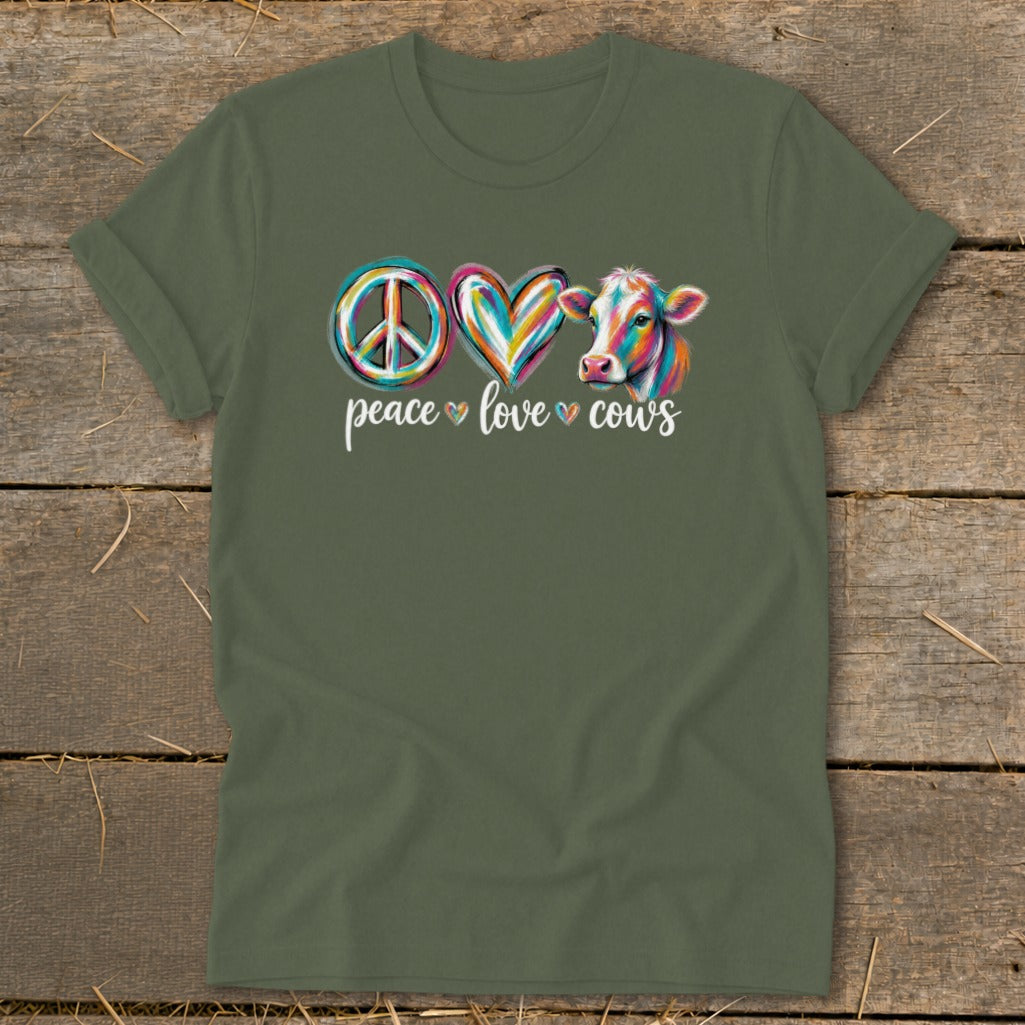Green t-shirt with colorful peace sign, heart, and cow graphic and text.
