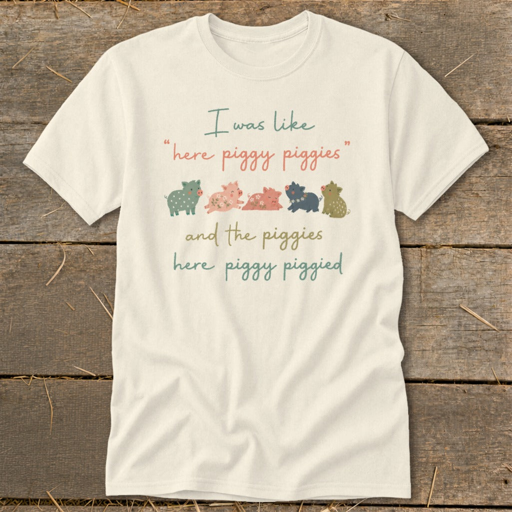 Cream t-shirt with cartoon pigs and text "I was like 'here piggy piggies' and the piggies here piggy piggied".