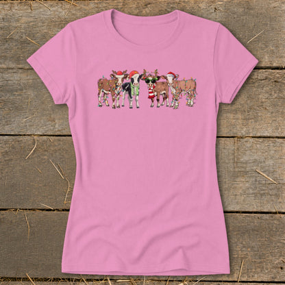 Pink t-shirt featuring a group of cartoon cows wearing Christmas hats and lights.