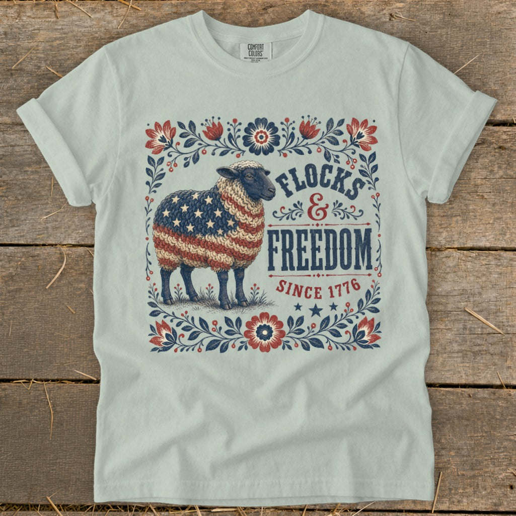 Sheep with American flag fleece and "Flocks & Freedom Since 1776" text.