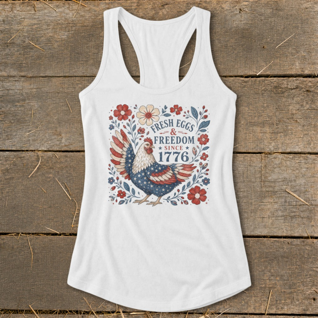 White tank top with patriotic chicken graphic and text "FRESH EGGS & FREEDOM SINCE 1776".