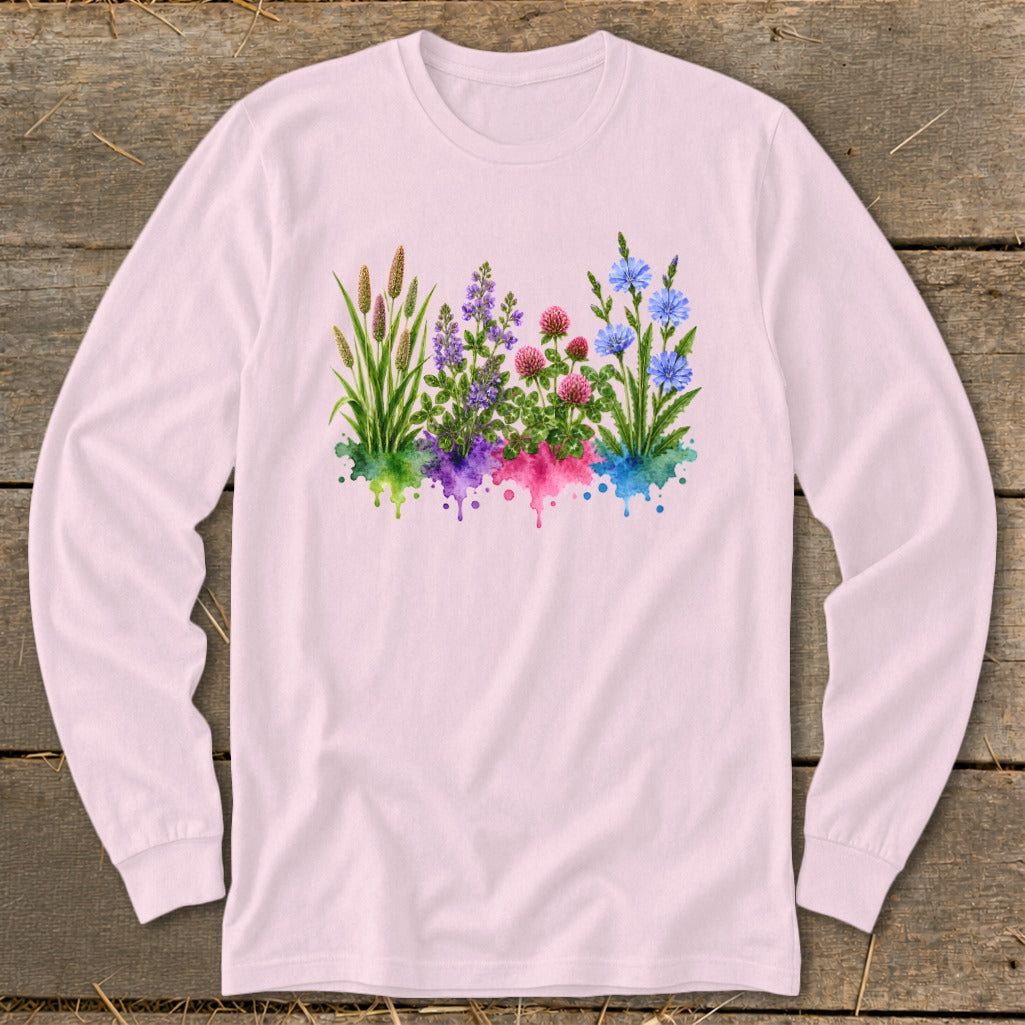 Light pink long-sleeve t-shirt with a colorful watercolor botanical illustration of grasses and wildflowers on the front.