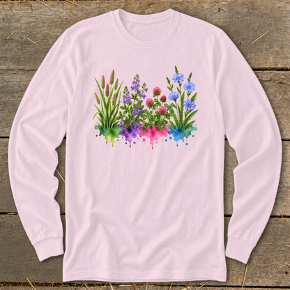 Light pink long-sleeve t-shirt with a colorful watercolor botanical illustration of grasses and wildflowers on the front.