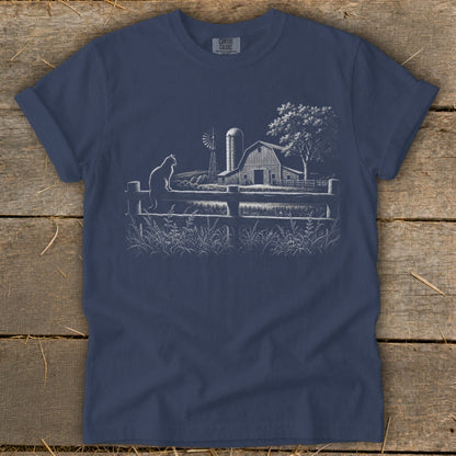 T-shirt with a white line drawing of a cat on a fence, barn, windmill, and tree.