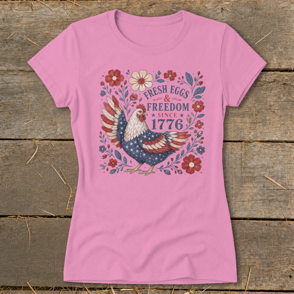 Pink t-shirt with a patriotic hen design and "Fresh Eggs & Freedom Since 1776" text.