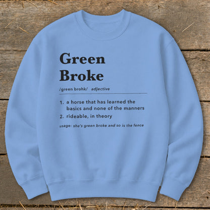 Light blue crewneck sweatshirt featuring black dictionary-style text defining the term Green Broke, displayed on a wooden background.