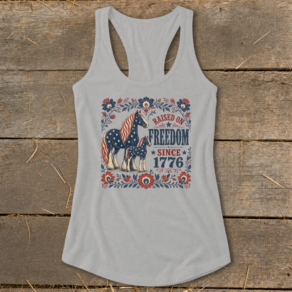 Grey tank top with patriotic horses and floral border, text reads "Raised on Freedom Since 1776".