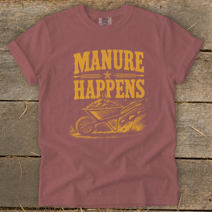 T-shirt with "MANURE HAPPENS" text and illustration of a wheelbarrow full of manure.