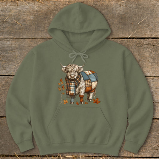 Highland cow wearing a plaid scarf and patchwork body, with autumn leaves.