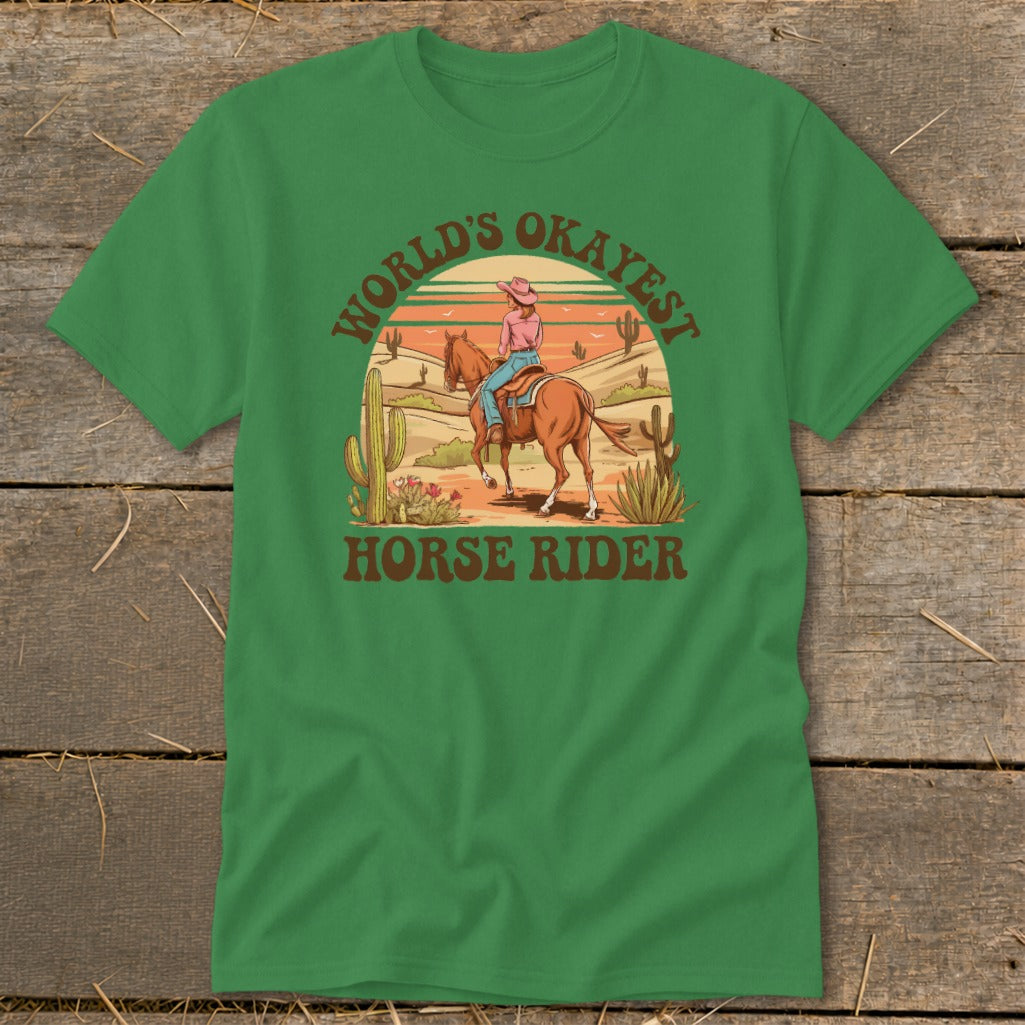 Green t-shirt with desert scene graphic reading "World's Okayest Horse Rider."
