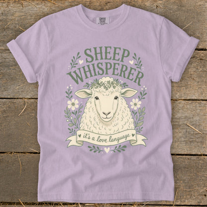Sheep Whisperer graphic t-shirt with a sheep illustration and floral wreath.