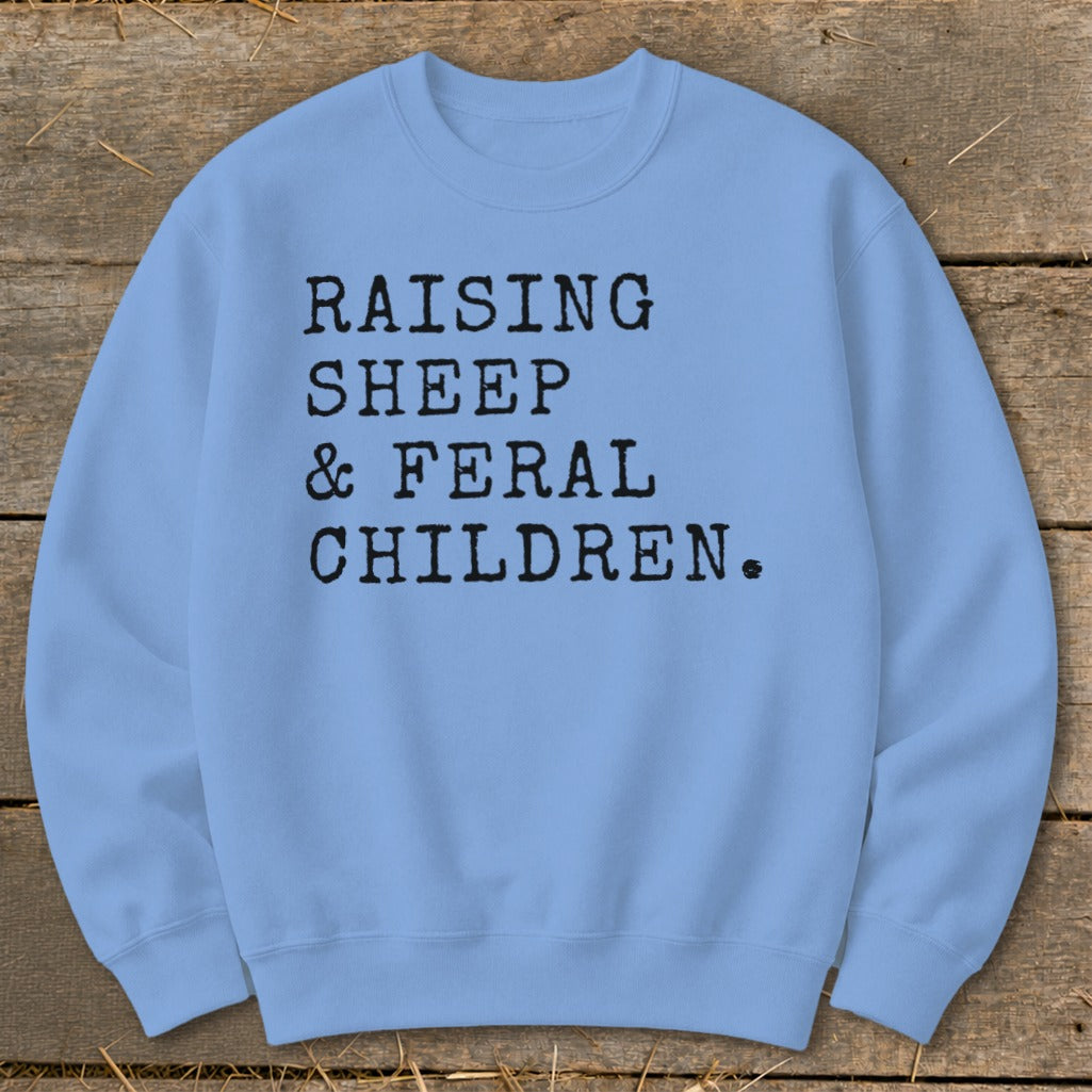 Light blue sweatshirt with black text: Raising Sheep & Feral Children.